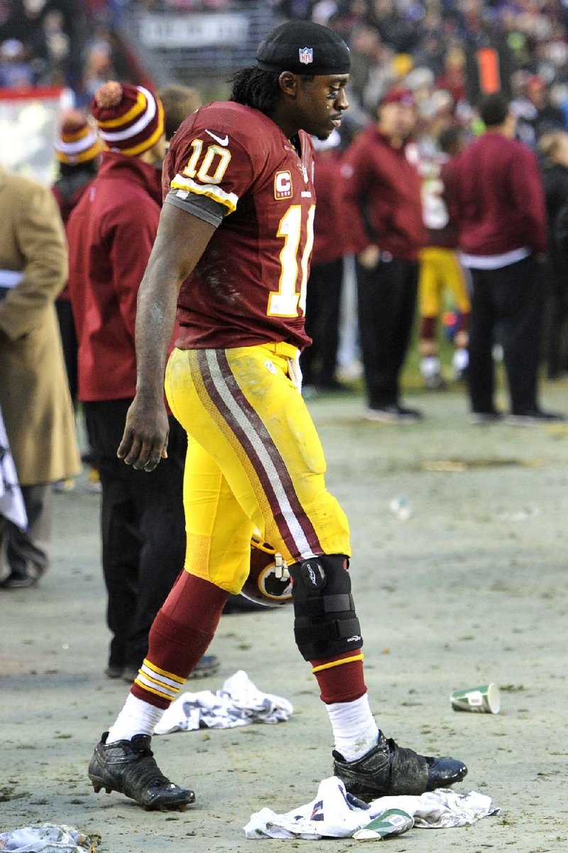 Washington Redskins rookie quarterback Robert Griffin III walks on the sideline with a brace on his knee during overtime Sunday afternoon against the Baltimore Ravens in Landover, Md. Griffin sprained his right knee in fourth quarter of the Redskins’ 31-28 overtime victory over the Ravens. 