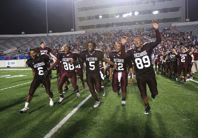 Stuttgart players (from left) Drelon Ice, Jorden Dorset, Waymon Johnson, Dontrell Brown and Carlin Warren rush onto the field to accept the Class 4A state championship trophy after defeating Ozark 28-7 on Saturday night at War Memorial Stadium in Little Rock. 