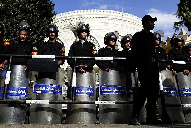 Egyptian riot police stand guard Saturday outside the presidential palace in Cairo.


