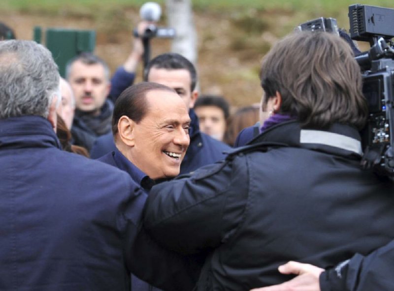 Silvio Berlusconi is surrounded by journalists Saturday near Milan, Italy, as he announces that he will again run for premier. 