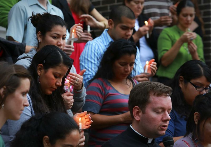 St. Edward Catholic Church pastor the Rev. Jason Tyler (bottom right) delivers a closing prayer after an immigration-rights rally Sunday afternoon on the steps of the Little Rock church. 