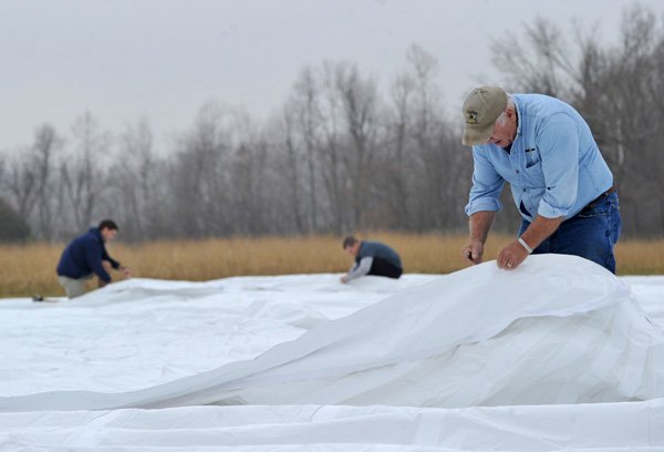 Ed Dugan with AAA Tents for Events in Springdale works with crews to set up a 48-by-135-foot tent Saturday morning at the Botanical Garden of the Ozarks in Fayetteville for a winter farmers market that will open Saturday. 