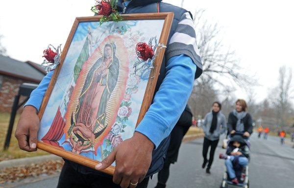 Ruben Alvarado Corona from St. Raphael Catholic Church in Springdale holds a picture of the Virgin Mary during the pilgrimage. 