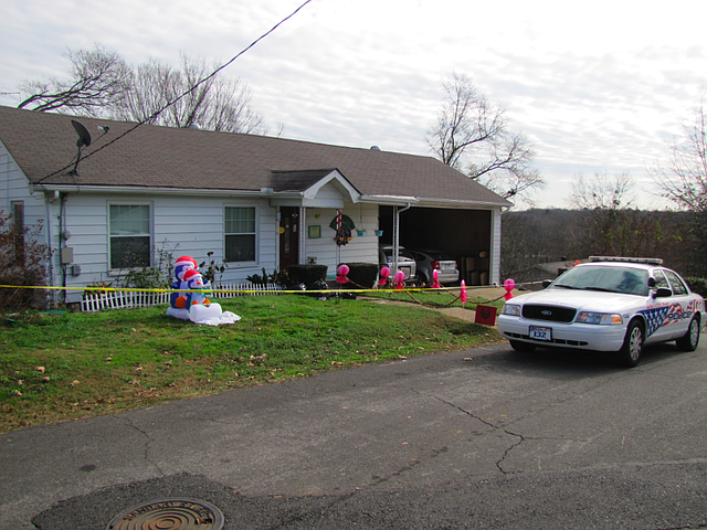 An Arkadelphia Police Department unit stands guard Monday at a house where a man and his two young stepdaughters were slain Thursday night.