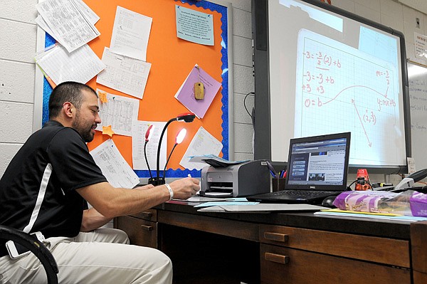 Eric Chavez, math tutor at Southwest Junior High School, runs through how to solve an equation Thursday during a tutoring session. 