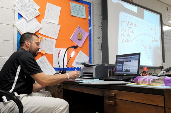 Eric Chavez, math tutor at Southwest Junior High School, runs through how to solve an equation Thursday during a tutoring session. 