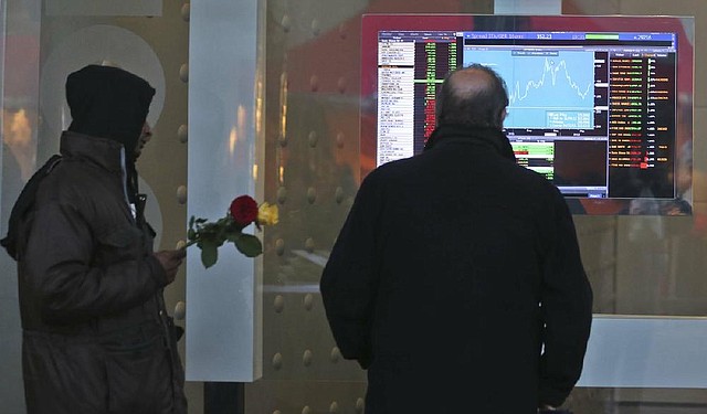 A man in Milan, Italy, checks the Italian stock exchange Monday as the country’s stock market fell and Italy saw its borrowing costs jump as investors and European leaders worried about Prime Minister Mario Monti’s decision to resign earlier than expected. 