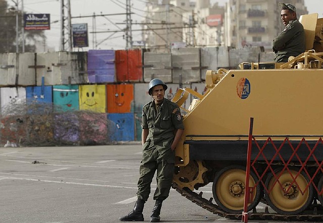 Egyptian soldiers in an armored vehicle guard the front of the presidential palace in Cairo on Monday. 