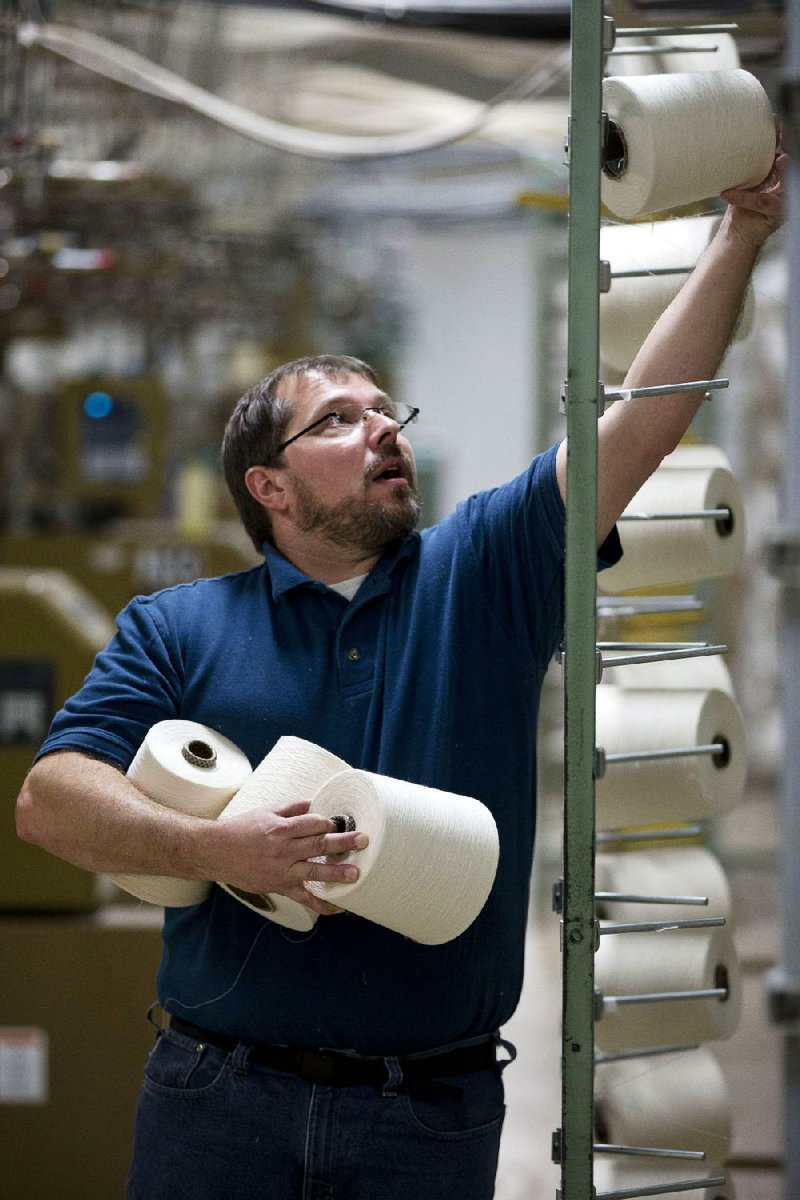 Mike Hartman moves spools of thread at FesslerUSA apparel in Orwigsburg, Pa., in October. The U.S. Commerce Department reported Tuesday that wholesale businesses increased stockpiles in October but saw their sales fall, a mixed sign for economic growth. 