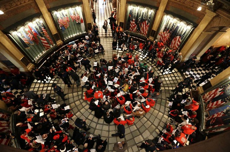 People protesting Michigan’s new labor law ÿll the state Capitol rotunda in Lansing on Tuesday. As the crowd grew, authorities closed the building, saying it had reached its capacity of more than 2,000. 