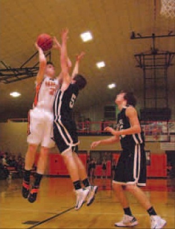 Carson Pollreis, a Gravette forward, takes a shot over Pea Ridge guard Evan Tillman during play in Gravette on Tuesday night. 