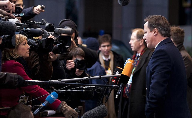 British Prime Minister David Cameron (right) talks to reporters Thursday as he arrived for a European Union meeting in Brussels. 