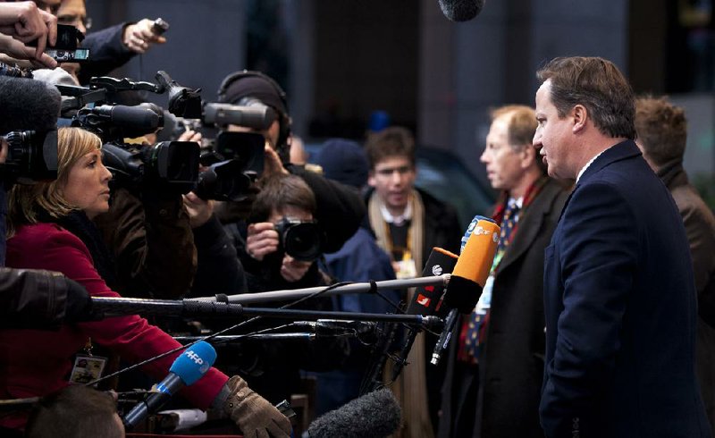 British Prime Minister David Cameron (right) talks to reporters Thursday as he arrived for a European Union meeting in Brussels. 