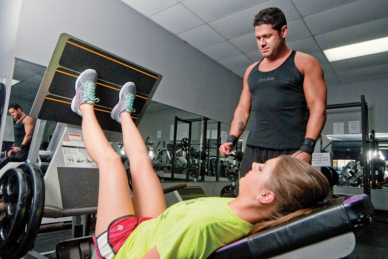 Personal trainer Brian Styles, right, watches Jade Webb do leg presses at Prevail Fitness in Cabot.