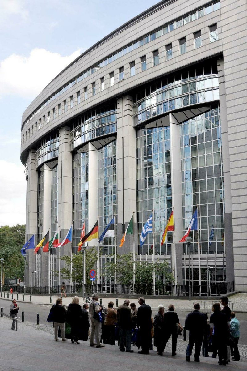 Tourists view the glassy facade of the Paul-Henri Spaak Building, home of the European Parliament in Brussels. 