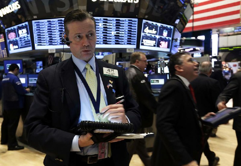 Trader Neil Catania (left) works Friday on the floor of the New York Stock Exchange, where losing stocks outnumbered gainers. 