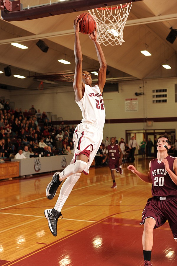 Dashaun Stark, a Springdale senior, dunks the ball as Benton center Josh Bowling trails the play during the first half Friday at Springdale High. 