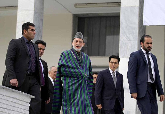 President Hamid Karzai (center) arrives Saturday at an Afghan foreign-policy strategy conference in Kabul. “There will be a change in our relations with the world in 2013,” he said. 