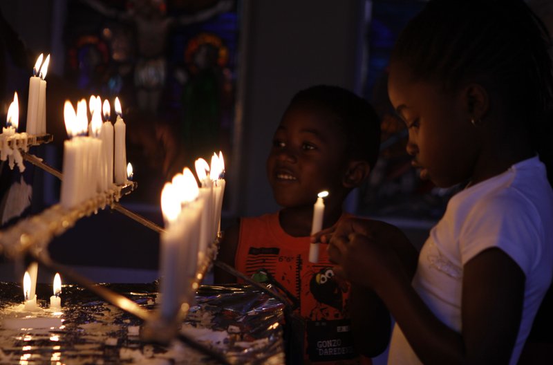 Worshippers light candles and dedicate prayers at the Rosebank Catholic Church in Johannesburg, Sunday, Dec. 16, 2012. South Africa's former President Nelson Mandela underwent a successful surgery to remove gallstones Saturday, the nation's presidency said, as the 94-year-old anti-apartheid icon is still recovering from a lung infection. Doctors treating Mandela waited to perform the endoscopic surgery as they wanted to first attend to his lung ailment, presidential spokesman Mac Maharaj said in a statement. Mandela has been hospitalized since Dec. 8.