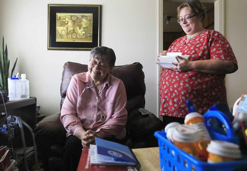Jeanne (left), 71, who doesn’t want her last name used, suffers from a number of ailments and lives alone in North Little Rock. She is dependent on her caregiver, Tracy Armstrong (right), and the regular nursing visits paid for by Medicaid. 