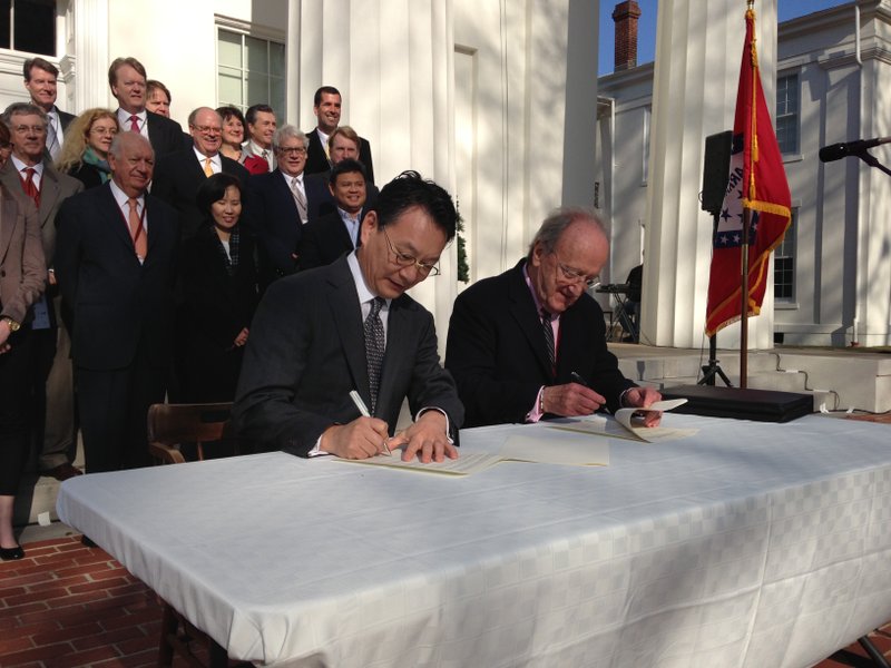 Carlos Westendorp, right, Club de Madrid Secretary General and Eugene Yun, left, Managing Director of the P-80 Foundation, sign the Little Rock Accord in front of the Old State House in downtown Little Rock.
