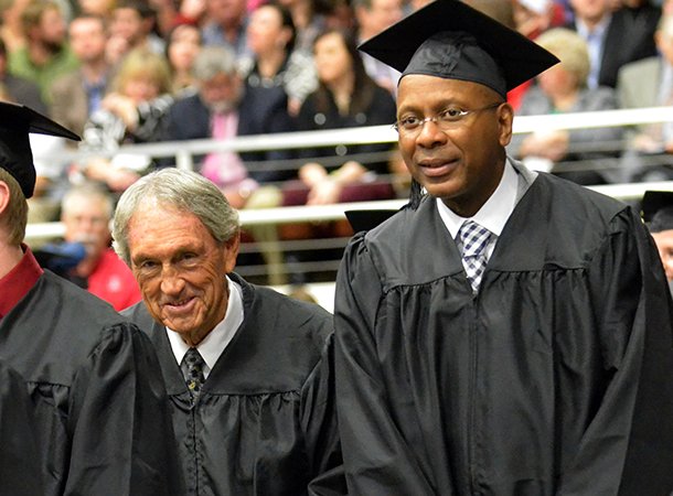 NWA Media/MICHAEL WOODS --12/15/2012-- Former University of Arkansas basketball player Darrell Walker, right, who played with the Razorbacks from 1980-83 is accompanied by former University of Arkansas basketball coach Eddie Sutton who coached at Arkansas from 1974-1985, as they participate in the fall commencement ceremony at Barnhill Arena in Fayetteville on Saturday morning. Sutton had the honor of presenting Walker with his degree. Over 800 undergraduate, graduate and law students who completed their studies during the summer or fall semesters will took part in the commencement ceremony.