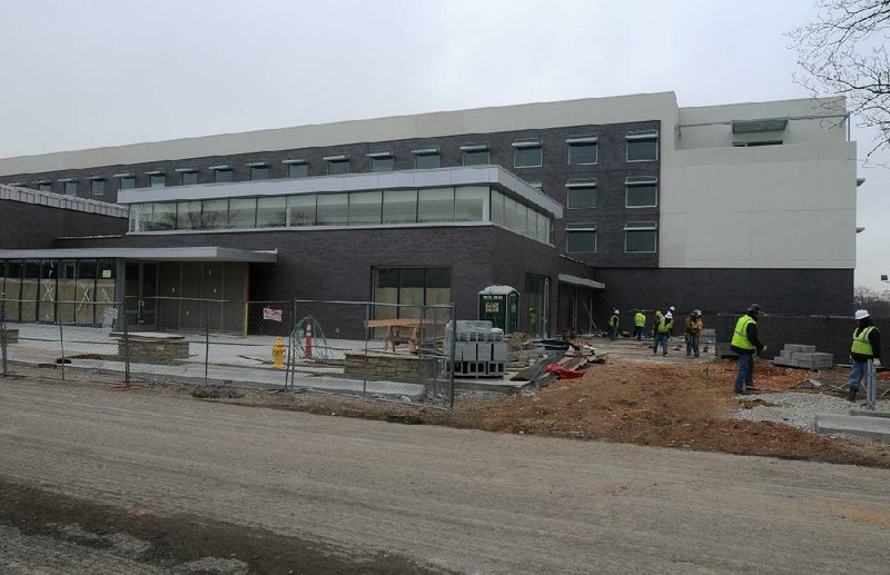 Construction crews continue to work Monday on the 21c Museum Hotel in downtown Bentonville. The hotel is accepting reservations on or after March 10 for its 104 guest rooms.