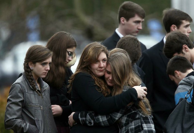 Mourners comfort one another as they leave a funeral service for 6-year-old Noah Pozner on Monday in Fairfield, Conn. Noah and classmate Jack Pinto were buried Monday.