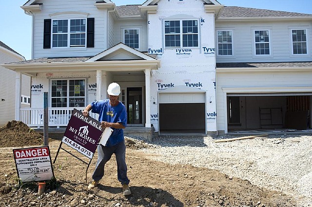 A construction worker places a sign in the front yard of a house in the Fox Glen subdivision of Pickerington, Ohio, in August. The National Association of Home Builders/Wells Fargo builder sentiment index this month said builders reported a good market for newly built homes. 