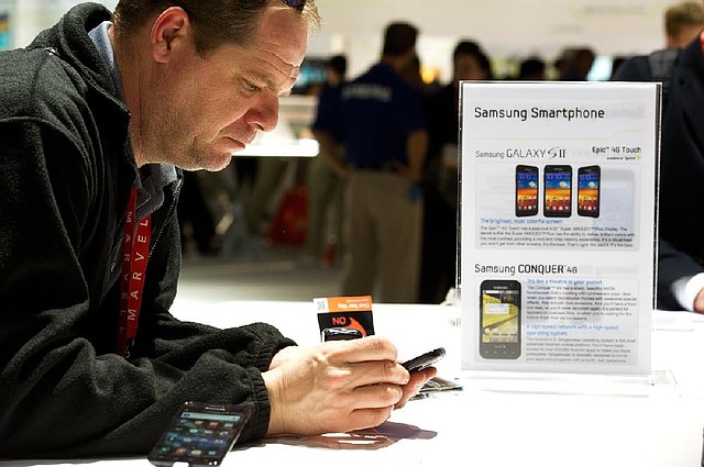 A visitor at the Consumer Electronics Show in Las Vegas looks at a Samsung Electronics Co. Galaxy S II phone earlier this year. A federal judge Monday rejected Apple Inc.’s demand that Samsung stop selling phones found infringing on Apple patents. 