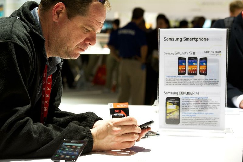 A visitor at the Consumer Electronics Show in Las Vegas looks at a Samsung Electronics Co. Galaxy S II phone earlier this year. A federal judge Monday rejected Apple Inc.’s demand that Samsung stop selling phones found infringing on Apple patents. 
