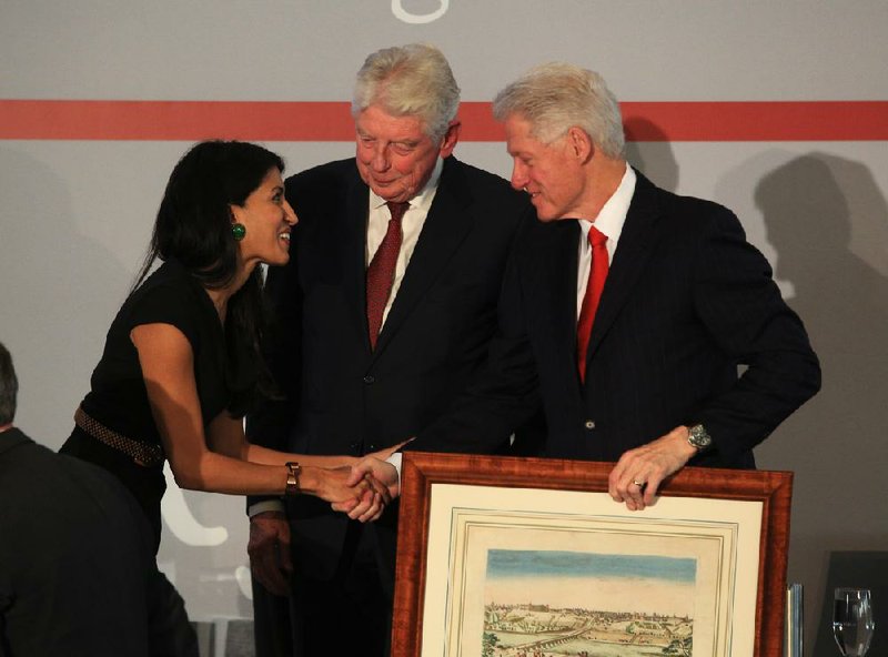 Leila Janah greets former President Bill Clinton and Club de Madrid President Wim Kok (center), the former prime minister of the Netherlands, as she receives the group’s Young Leadership Award on Tuesday afternoon at the Clinton Presidential Center in Little Rock. 