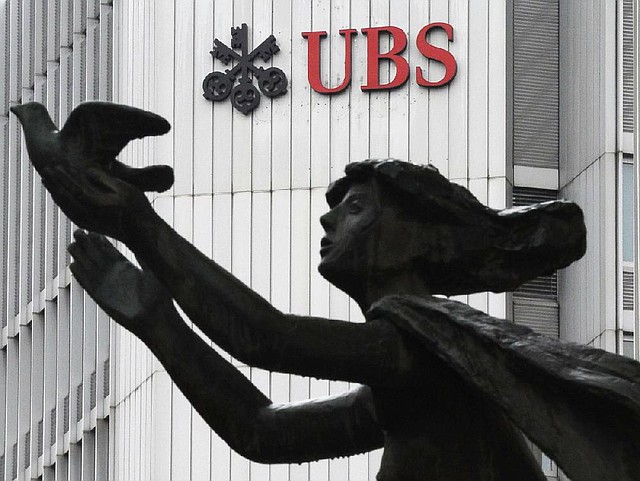 FILE - In this March 19, 2012 file photo the logo of the Swiss bank UBS is pictured behind a statue in Zurich, Switzerland. UBS AG agreed Wednesday, Dec. 19, 2012 to pay some US$1.5 billion in fines to international regulators following a probe into the rigging of a key global interest rate. In admitting to fraud, Switzerland's largest bank became the second bank, after Britain's Barclays PLC, to settle over the rate-rigging scandal. The fine, which will be paid to authorities in the U.S., Britain and Switzerland, also comes just over a week after HSBC PLC agreed to pay nearly US$2 billion for alleged money laundering.  (AP Photo/Keystone, Steffen Schmidt)