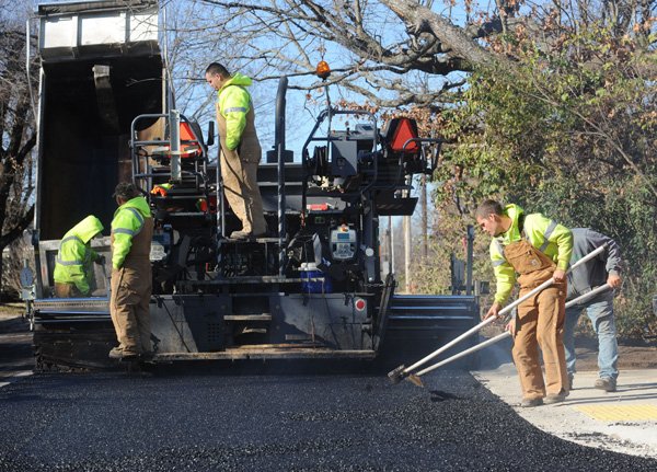 Steve Jones, from left, Alford Main, Josh Myers, John Ragsdale and Alfred DeRoche, Fayetteville Transportation Division workers, work Wednesday while completing a paving project at Holly Street and North Oakland Avenue. 