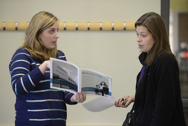 Emily Hirsch (left), Arkansas campus director for Responsive Education Solutions, answers questions for Venetia Muench of Rogers during a public information session about the planned Northwest Arkansas Classical Academy charter school Tuesday at the Bentonville Public Library. Muench, who has two young children, said she wants to look into all of the educational options for her kids. 