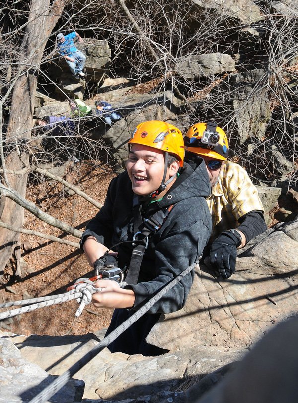 Jonathan Barrientos, a Rogers High School student with cerebral palsy, rappels down a cliff with outdoor education instructor Jeff Belk Dec. 12 at Lincoln Lake. Rappelling and rock climbing are two of many skills students learn in outdoor education at RHS and other area schools. 
