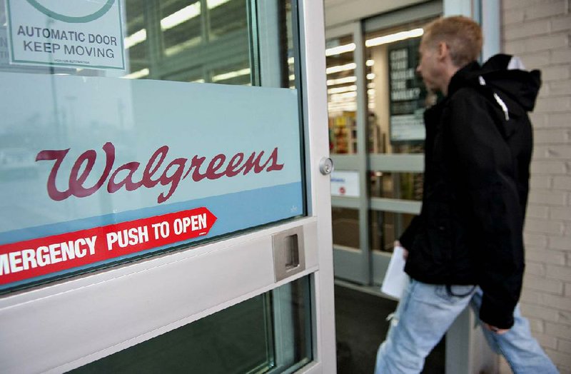 A customer enters a Walgreen Co. store in Chicago earlier this year. The company reported that overall it earned $413 million in the three months that ended Nov. 30. 