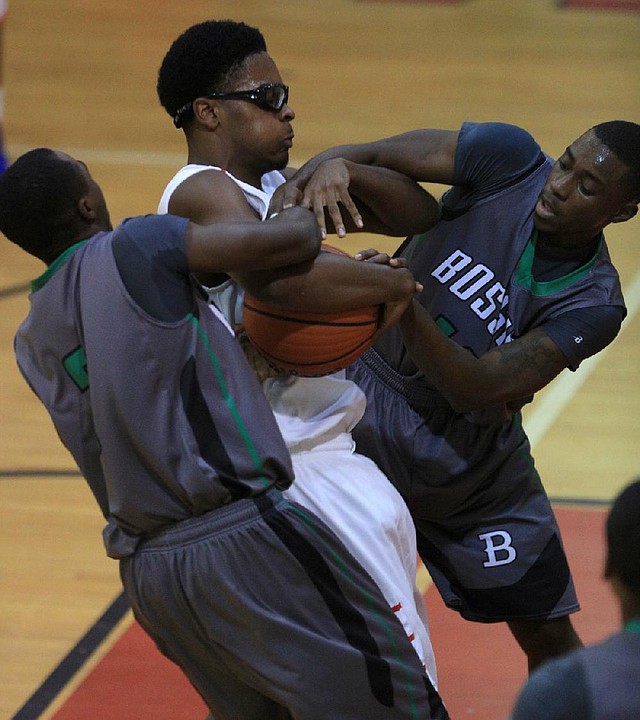 Little Rock McClellan’s Jason Hendrix (center) fights for a loose ball with Breon Morris (left) and Deorvion Robinson of Bossier City, La., during the Hardwood Showcase on Friday at Jacksonville High School. Hendrix finished with 10 points as McClellan lost 75-46 