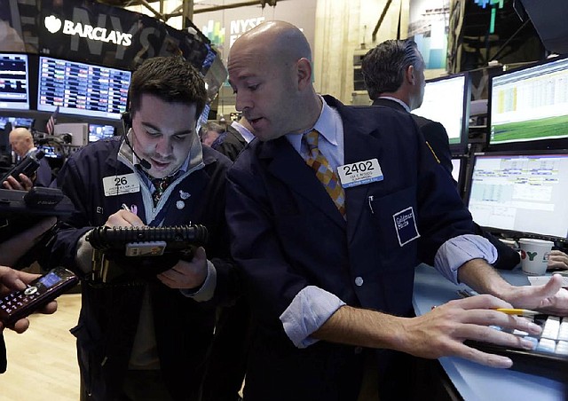 Trader Joseph Lawler (left) and specialist Jay Woods work Friday on the floor of the New York Stock Exchange, where stocks fell after a U.S. House bill to avoid end-of-the-year tax increases and government spending cuts stalled.