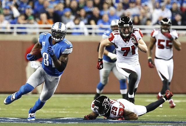 Detroit Lions wide receiver Calvin Johnson (left) catches one of his 11 receptions Saturday night against the Atlanta Falcons at Ford Field in Detroit. Johnson broke Jerry Rice’s NFL single-season receiving yards mark of 1,848 and also became the ÿrst player with 100 yards receiving in eight consecutive games the ÿrst with 10 receptions in four games in a row. 