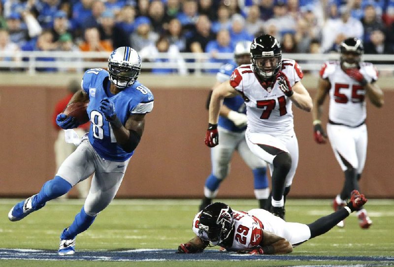 Detroit Lions wide receiver Calvin Johnson (left) catches one of his 11 receptions Saturday night against the Atlanta Falcons at Ford Field in Detroit. Johnson broke Jerry Rice’s NFL single-season receiving yards mark of 1,848 and also became the ÿrst player with 100 yards receiving in eight consecutive games the ÿrst with 10 receptions in four games in a row. 