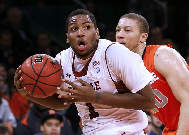 Temple guard Khalif Wyatt drives past Syracuse defender Brandon Triche (right) during the ÿrst half of Saturday’s game in the Gotham Classic at Madison Square Garden in New York. Wyatt ÿnished with a game-high 33 points as Temple upset No. 3 Syracuse 83-79. 