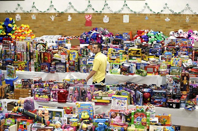 Volunteer Anthony Vessicchio of East Haven, Conn., helps sort tables filled with donated toys Friday at the town hall in Newtown, Conn. 