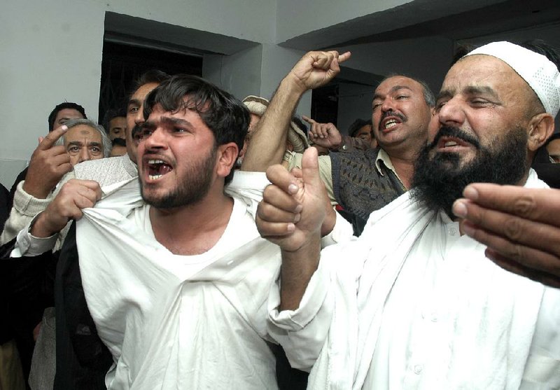 Supporters of Pakistani Khyber Pakhtunkhwa province’s senior minister, Bashir Bilour, who was killed in a suicide bombing, mourn over Bilour’s death Saturday at a hospital in Peshawar, Pakistan. 