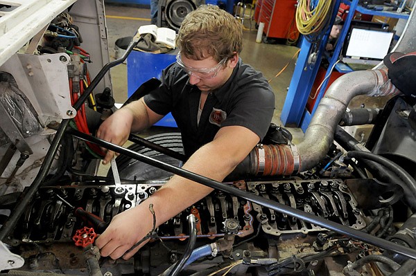 Corbin Hulsizer adjusts the lifters on a diesel engine Dec. 12 at Northwest Technical Institute in Springdale. The program has a high placement rate and illustrates the area’s need for skilled labor, experts said. 