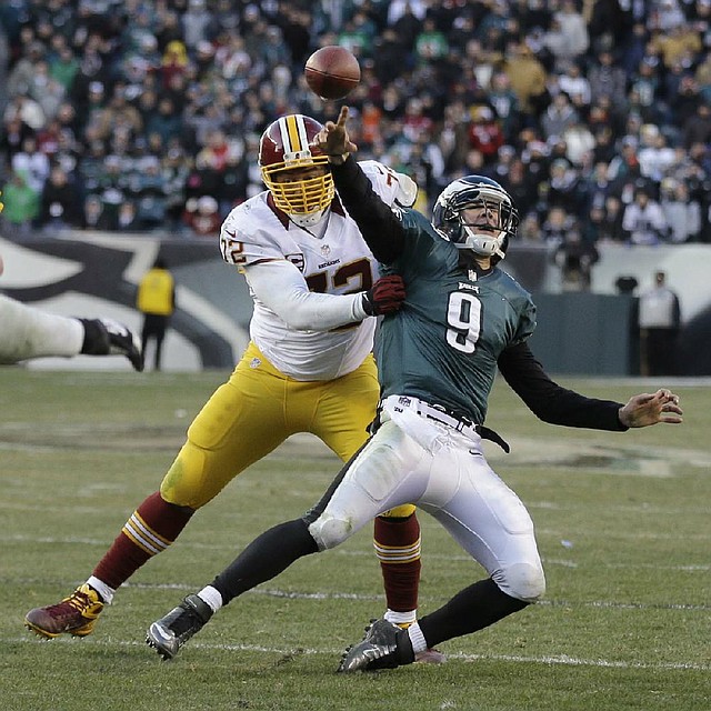 Philadelphia Eagles' Nick Foles passes the ball as Washington Redskins' Stephen Bowen brings him down during the final seconds of an NFL football game, Sunday, Dec. 23, 2012, in Philadelphia. Foles was called for intentional grounding on the game-ending play. Washington won 27-20. (AP Photo/Mel Evans)