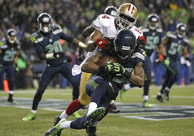 Seattle Seahawks' Richard Sherman comes down with an interception ahead of San Francisco 49ers' wide receiver Randy Moss in the second half of an NFL football game, Sunday, Dec. 23, 2012, in Seattle. The Seahawks beat the 49ers 42-13. (AP Photo/John Froschauer)