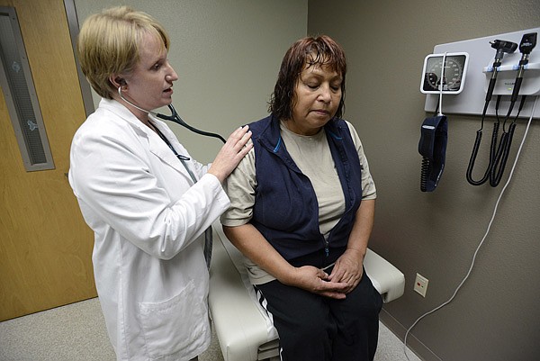 Jennifer Jennings, nurse practitioner, checks Sophia Sanchez’s breathing Thursday while giving the Rogers resident an examination at Community Clinic in Rogers. 