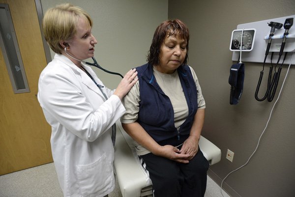 Jennifer Jennings, nurse practitioner, checks Sophia Sanchez’s breathing Thursday while giving the Rogers resident an examination at Community Clinic in Rogers. 