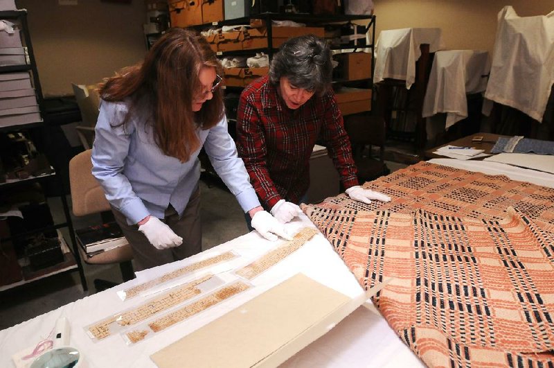 NWA MEDIA/SAMANTHA BAKER
Carolyn Reno, collections manager with Shiloh Museum of Ozark History, left, and Marty Benson, a member of the Northwest Arkansas Handweavers Guild, look over coverlet drafts Tuesday, Dec. 18, 2012, at Shiloh Museum of Ozark History. Laura Redford and Marty Benson from the Northwest Arkansas Handweavers Guild have been researching 26 coverlets the museum has to learn more about the way they were made and the lives of the people who made them. Drafts are instructional guides for weavers to follow to achieve a particular pattern.